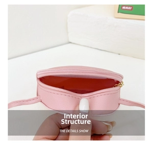 Close-up of pink heart-shaped mini bag showing interior red lining and golden zipper detail