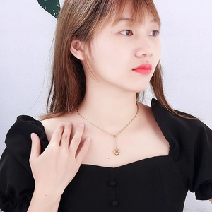 Elegant gold heart pendant necklace on model with minimalist titanium steel chain