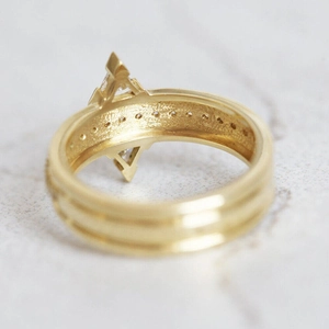 Macro detail of golden geometric triangle ring with micro-pave cubic zirconia inlay