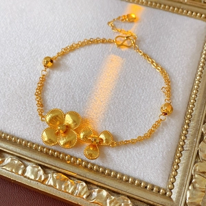 Detail of vintage gold plated double-layer floral bracelet with matte flower charms