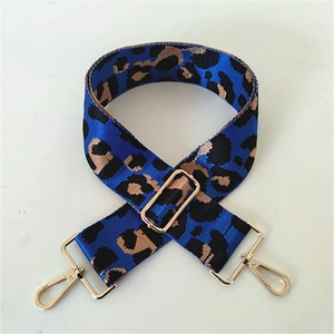 Close-up of royal blue leopard print bag strap with polished gold-toned metal hooks