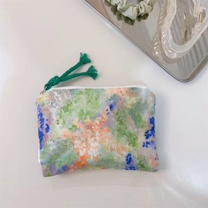 Macro detail of oil painting style cotton coin purse with zipper and green tassel charm
