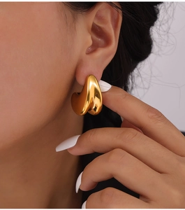 Detail shot of elegant double-layered gold-plated waterdrop stud earrings on model