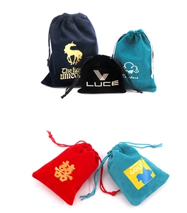 Detailed view of five colored velvet drawstring pouches with various printed logos