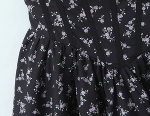 Close-up of waist stitching and purple floral pattern on black vintage dress