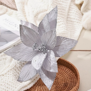 Fleur de poinsettia artificielle argentée pailletée sur un plateau en osier