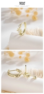Detail view of gold starburst ear cuff showing screw design and crystal inlay