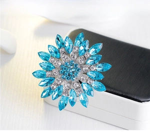 Macro shot of blue floral crystal brooch with radiant silver-toned rhinestone petals