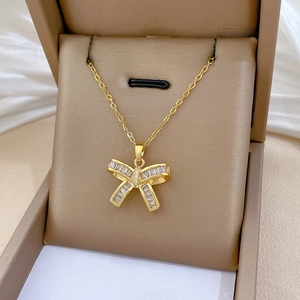 Detailed close-up of a luxury gold butterfly pendant with rectangular zircon in a jewelry box