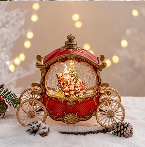 Detailed view of a red and gold pumpkin carriage snow globe with Santa and warm lights