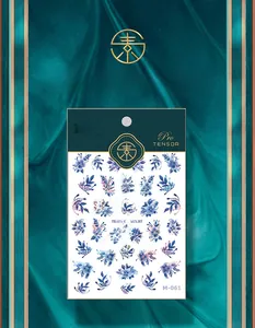 Macro detail of M-061 laser floral nail stickers with blue blossoms and elegant packaging