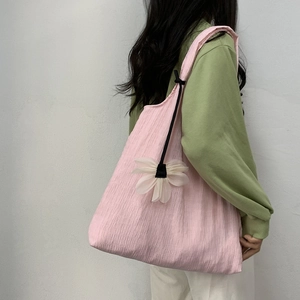 Pink pleated canvas tote bag detail with white 3D flower charm and textured fabric