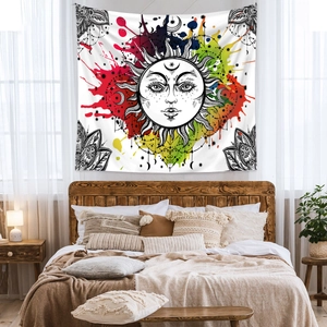 Detail of bohemian sun and moon tapestry with colorful ink splatters in a bedroom