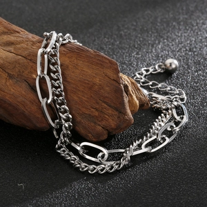 Detail of silver double-layered metal chain bracelet on a rustic wood stand