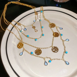 Detailed close-up of multi-layer boho necklace with tiger eye beads and gold pendants