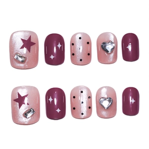 Pink cat eye press-on nails with purple stars, black polka dots and crystal accents