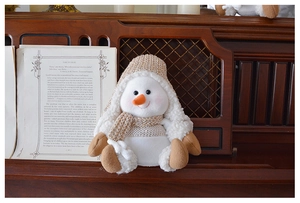 Macro shot of snowman plush with golden knit hat and scarf on vintage piano stand
