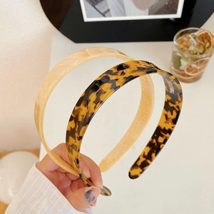 Detailed view of tortoiseshell and cream acetate headbands with inner grip teeth
