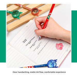 Close-up of hand writing with a festive reindeer horn Christmas gel pen on a notebook