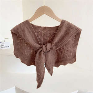 Brown knitted hollow shawl with tie-front design on a wooden hanger for autumn