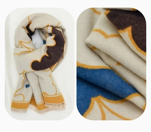 Detail of beige wool scarf showing fringe edges and soft abstract pattern texture