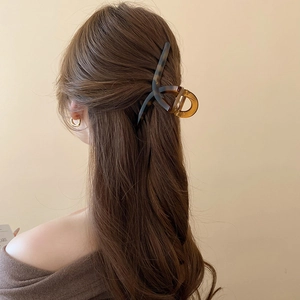 Close-up of a vintage tortoiseshell hair claw clip securing a half-up hairstyle