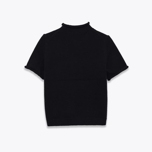 Close-up of black mock neck knit top featuring delicate rolled edge detailing and soft texture