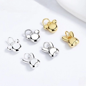 Close-up of 925 sterling silver hollow cat and mouse charms in gold and silver finish