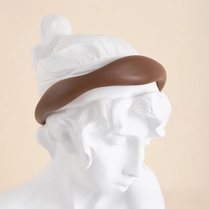 Detail of vintage coffee brown leather headband on a classical statue head for styling