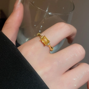 Macro shot of vintage gold ring with yellow zircon stone and intricate side engraving