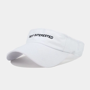 Close-up of white sun visor with black NOT INTERESTED embroidery and cotton texture