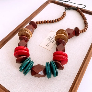 Detail of bohemian necklace with large wood and resin beads in geometric shapes