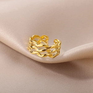 Detail of 18k gold plated triple-layer wavy open ring on champagne satin fabric