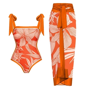 Detail of orange floral one-piece swimsuit and matching wrap skirt with shoulder bows