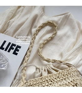Detail of hand-woven straw bag showing braided shoulder straps and drawstring lining