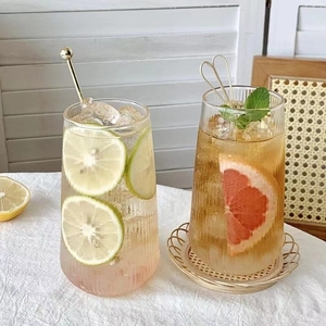 Detailed view of vertical ribbed glass cups with fresh lemon and grapefruit cold drinks