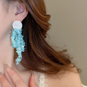 Detail of light blue pebble tassel earrings worn for a summer vacation look