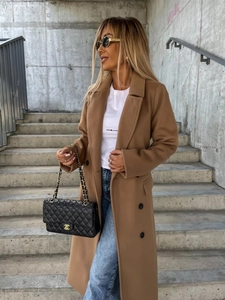 Detail of camel wool coat with buttons styled with a luxury chain bag and blue jeans