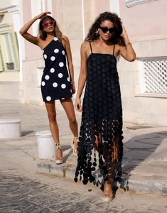 Detail of 3D textured applique and cutout hollow design on a black French summer dress