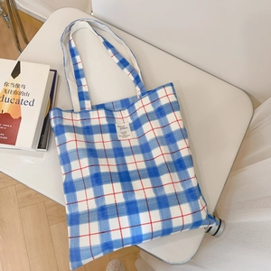Detailed macro of a blue and white checkered canvas tote bag with a woven textile label