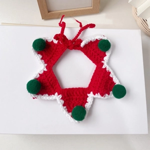 Détail d'un bavoir de Noël pour animaux fait main au crochet avec étoiles rouges et pompons