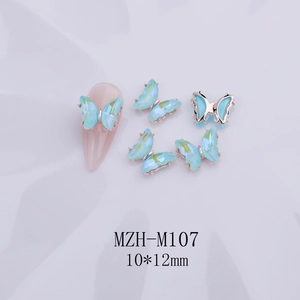 Vista macro de dijes para uñas de mariposa de cristal azul claro con detalles facetados