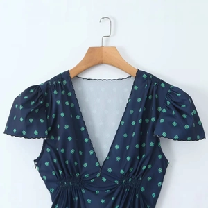 Navy blue V-neck dress with green floral print, puff sleeves and elastic waist