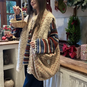 Detail of plush fleece tote bag with red floral pattern and matching white vest