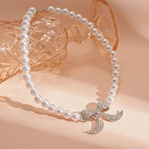 Dettaglio della collana di perle vintage con ciondolo a fiocco di diamanti su vetro
