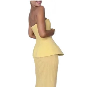 Women's yellow two-piece set featuring a peplum tube top and ribbed knit midi skirt