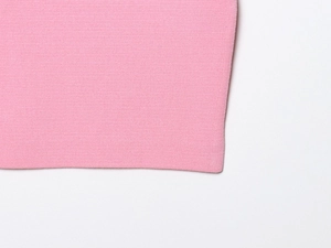 Close-up of pink knitted ribbed fabric texture showing detailed vertical weave pattern