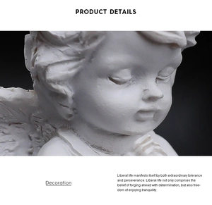 Close-up of a white resin angel sculpture showing intricate facial details and prayer pose
