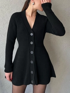 Détail d'une robe cardigan en maille noire à manches longues avec col en V et boutons