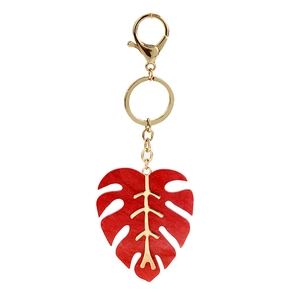 Detail view of red monstera leaf keychain with gold plating and marbled resin texture